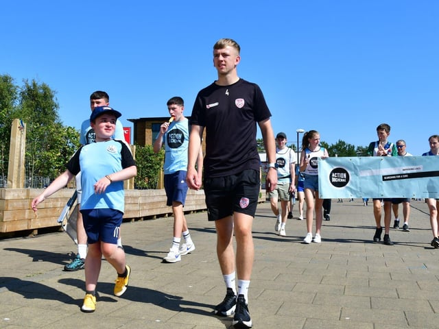 Derry City player Ciaron Harkin walking with 'football mad' Niall.