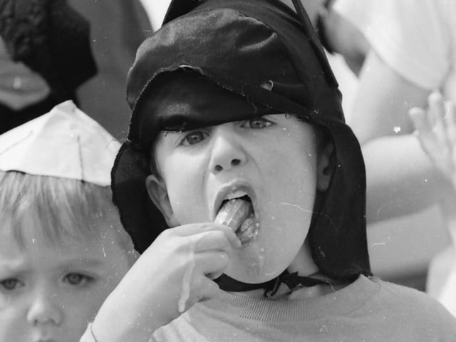 Batman cools down with an ice cream during the fancy dress parade at the