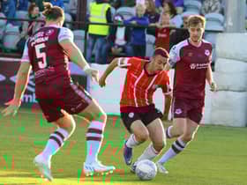 Derry City’s Michael Duffy skips in between Drogheda United defenders Keith Cowan (No 5) and Andrew Quinn.
