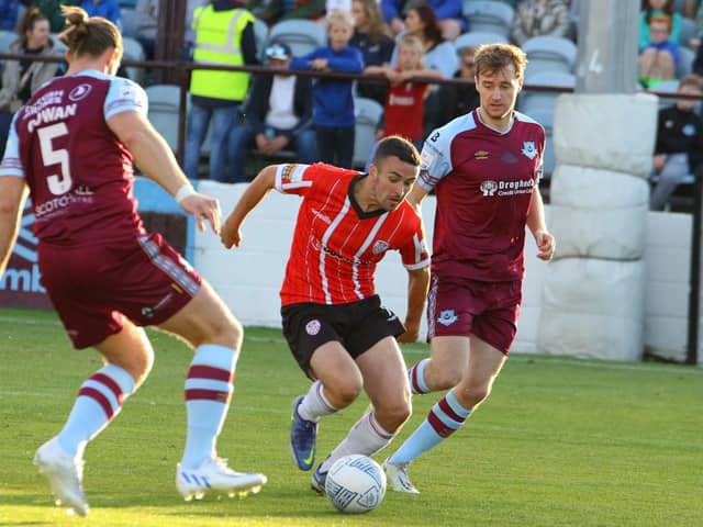 Derry City’s Michael Duffy skips in between Drogheda United defenders Keith Cowan (No 5) and Andrew Quinn.