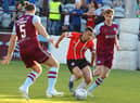 Derry City’s Michael Duffy skips in between Drogheda United defenders Keith Cowan (No 5) and Andrew Quinn.