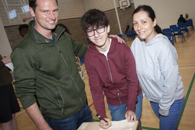 GCSE student Darragh Flood signing in to come back to St. Columbâ€TMs College next year after getting his results on Thursday morning. He is pictured with proud parents John and Irma.