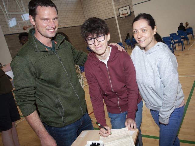 GCSE student Darragh Flood signing in to come back to St. Columbâ€TMs College next year after getting his results on Thursday morning. He is pictured with proud parents John and Irma.