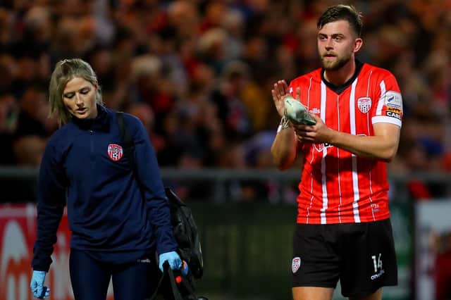Derry City's Will Patching walks off with physio Katy Holly, after aggravating an ankle injury against Cork City last Friday night.