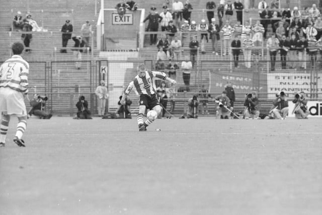 Celtic's Tosh McKinlay looks on as Eamon Doherty controls the ball in midfield.