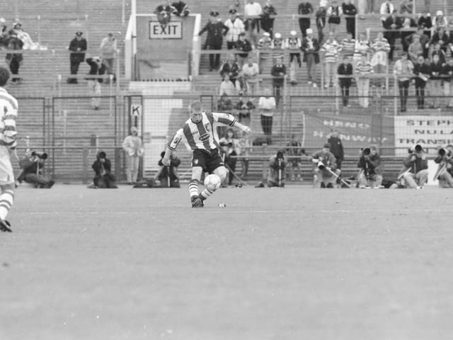 Celtic's Tosh McKinlay looks on as Eamon Doherty controls the ball in midfield.