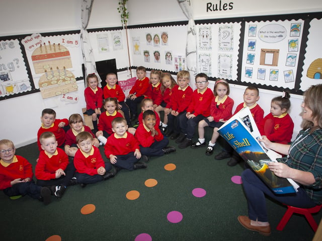 Mrs. Crampsey's P1 class at Steelstown PS listening intently to a story from Mrs. Catherine McCarron, Classroom Assistant.