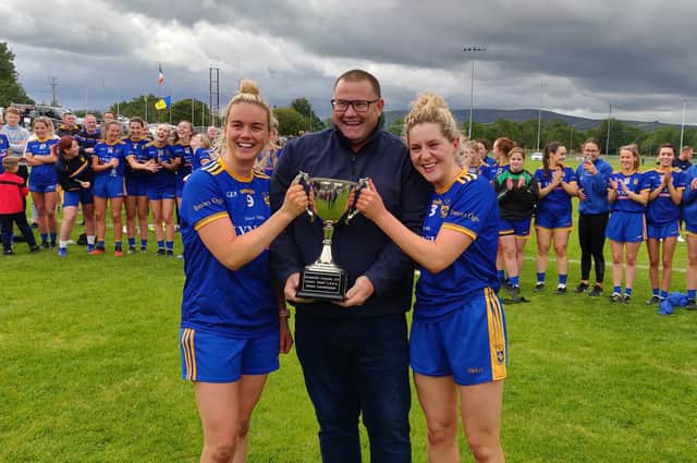 Joint Steelstown Ladies captains Ciara McGurk (left) and Aoife McGough receive the Derry Senior Championship trophy from Derry LGFA Chairperson, Sean Hamill after defeating Ballymaguigan in Glen on Sunday.