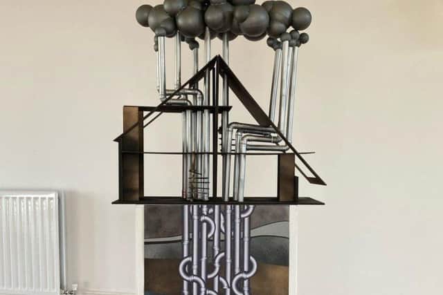 David Jacques' Dollhouse, which has encountered a mass of oil & gas pipes, refelcting on the fossil fuel industry.