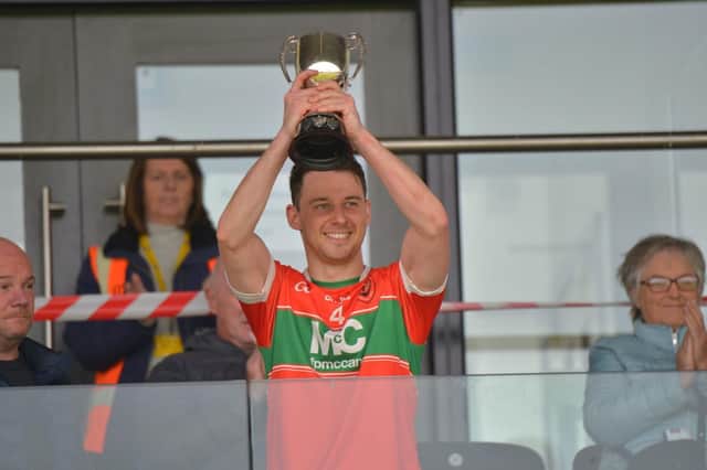 Lavey captain Shane McGill lifts the Derry Junior Championship trophy after their emphatic victory over Na Magha in Owenbeg on Sunday. (Photo: George Sweeney)