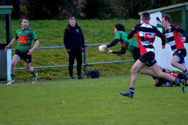Under pressure Killene Thornton off loads the ball to his City of Derry team mate Ian Bratton during the game against Cooke at Judges Road. (Photo: George Sweeney).