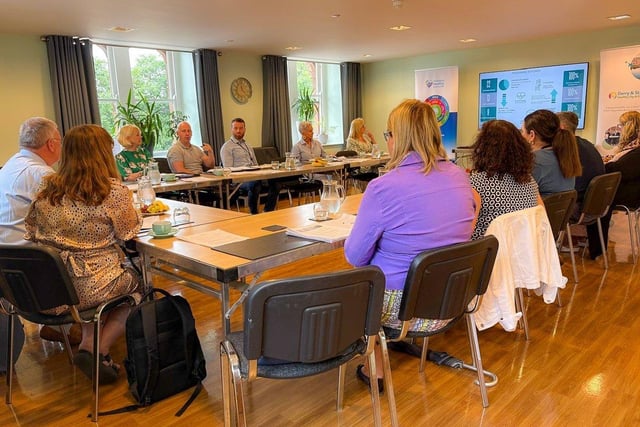 The Health Minister Mike Nesbitt pictured at a conference table, talking with Derry City and Strabane Healthy City and District Leadership Group.