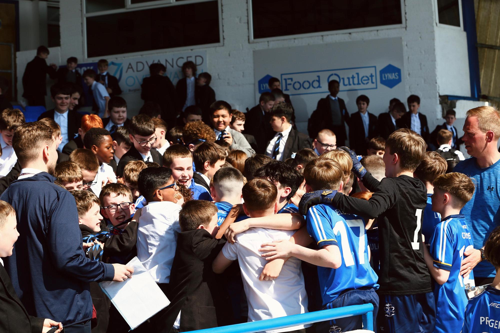 The U12 champions are mobbed by schoolmates at the Coleraine Showgrounds following their historic win.