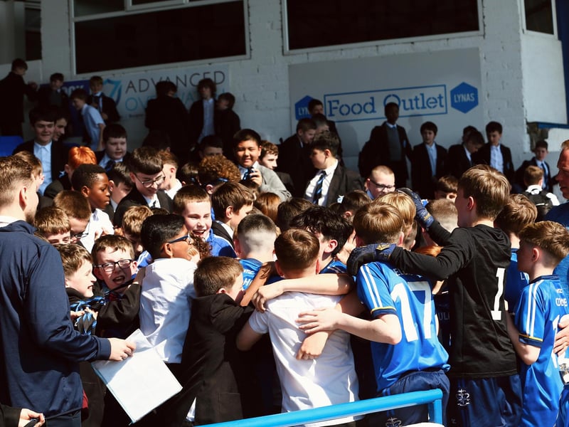 The U12 champions are mobbed by schoolmates at the Coleraine Showgrounds following their historic win.