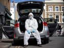 Uber driver Yasar Gorur wears personal protective equipment while cleaning his vehicle (Photo: Hollie Adams/Getty Images)