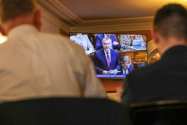 People watch a television showing a live broadcast of Ireland's Finance Minister Michael McGrath presenting the 2024 Irish Budget to Parliament, from a hotel in Dublin on October 10, 2023. (Photo by PAUL FAITH / AFP) (Photo by PAUL FAITH/AFP via Getty Images)