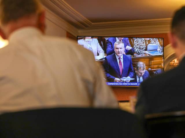 People watch a television showing a live broadcast of Ireland's Finance Minister Michael McGrath presenting the 2024 Irish Budget to Parliament, from a hotel in Dublin on October 10, 2023. (Photo by PAUL FAITH / AFP) (Photo by PAUL FAITH/AFP via Getty Images)