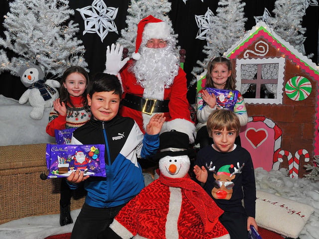 St Eithne’s Primary School P4 pupils Eadaoin, Saher, Harry and Portia from Mrs Coyle’s class pictured with Santa during his visit on Friday. Photo: George Sweeney. DER2250GS – 52