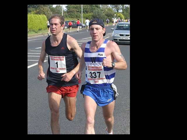 Leading the field of runners in the Waterside Half-Marathon at the halfway stage are Paul Rowan (1) and Alan McCullough (337). (1609T46).:.