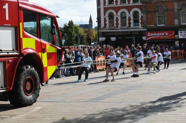 One of the fundraising teams pulls a 32-tonne City of Derry Airport Fire and Rescue Engine, in Guildhall Square, in aid of Children In Crossfire. Photo: George Sweeney