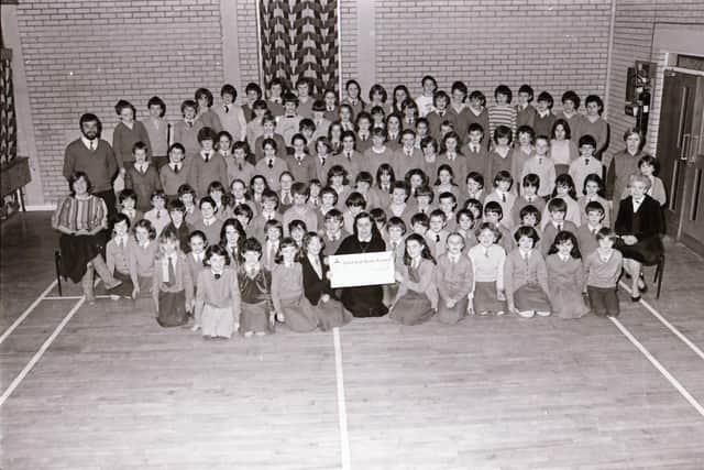 Sister Anna Doherty pictured in 1983 receiving a cheque for the Resource Centre from the children of Carnhill Primary School.