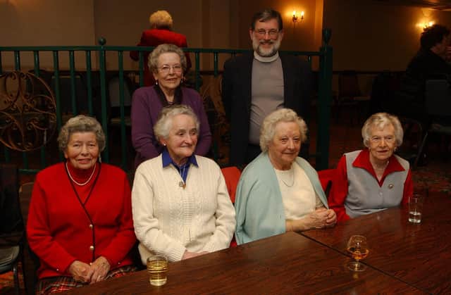 Seated from left, Kathleen Hegarty, Margaret Wilson, Annie McCartney, and Maureen Canning. Standing, from left, Annie Gillespie and Reverend Harry Gilmore. (0912PG36)                               :Christmas parties for Derry's senior citizens in December 2003