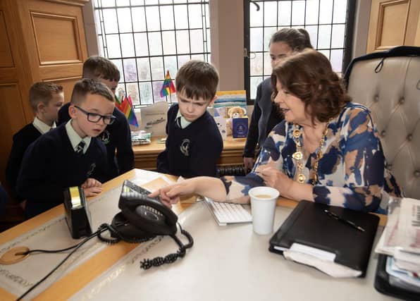 The Mayor, Patricia Logue explaining her phone system and its workings to pupils from the Long Tower PS on Thursday morning. at the Guildhall.