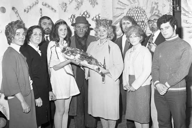 Ireland’s greatest actress Siobhan McKenna travels to Derry in June 1972 to guest-star in a one-off reprise of Friel’s The Loves of Cass McGuire. The photo shows Shantallow Festival Queen Frances Campbell (later Eurovision contestant with Sheeba and BBC radio presenter) presenting a bouquet of flowers to McKenna as Theatre Club members look on. From left are Deirdre McGinley, Terry Willman, Eddie Mailey, Kevin McLaughlin, Gerry Downey, Phillippa Russell, Bernard Toal (producer) and Bart O'Donnell. The picture appears on the front page of the Derry Journal.