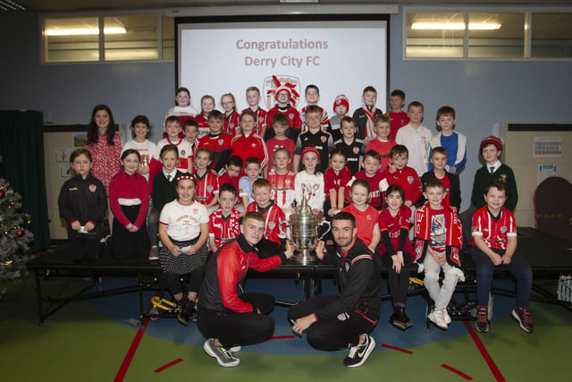 Derry players Caoimhin Porter and Michael Duffy and the FAI Cup pictured with the P4 classes at Greenhaw PS.