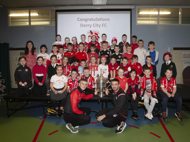 Derry players Caoimhin Porter and Michael Duffy and the FAI Cup pictured with the P4 classes at Greenhaw PS.