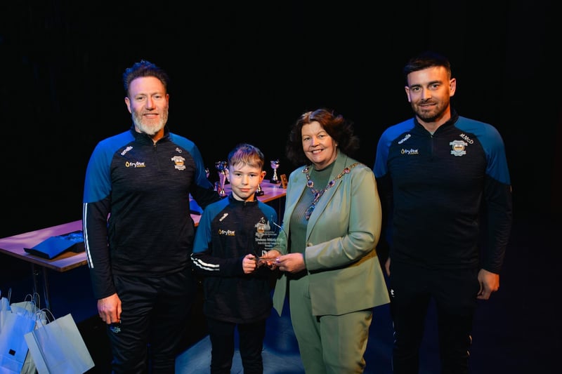 Coaches Steven Connolly and Marcus McDonald with young Noah Connolly, who captained the 2012 Colts who won the Summer Cup. Making a special presentation to the group at a Mayoral reception in The Alley Theatre is Derry City & Strabane District Council Mayor Patricia Logue. Photo: Karol McGonigle, Milkwood Studios.