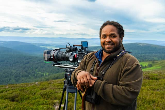 Wildlife cameraman Hamza Yassin stands with his camera in the Cairngorms National Park