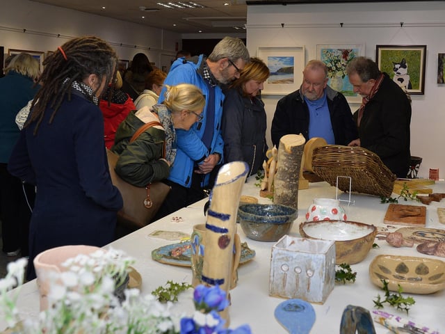 Visitors admire the exhibits on display at the recent Eden Place Arts Centre Student Christmas Exhibition. DER4718GS023