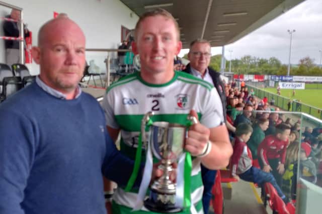 Swatragh captain Sean F Quinn receives the Derry Junior Championship trophy at Owenbeg on Sunday.