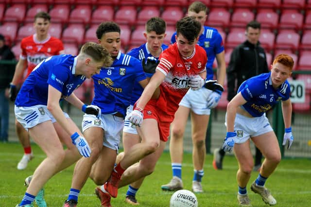 Cavan players converge on Derry’s Dylan Rocks at Owenbeg on Saturday. Photo: George Sweeney
