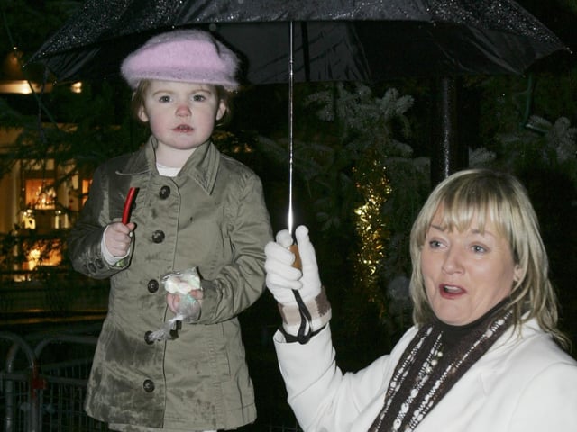 Paige Ferguson sheltered from the elements by her granny, Patricia Ferguson, as they await the arrival of Santa. (2911C30a) : Christmas events in Inishowen in December 2005.