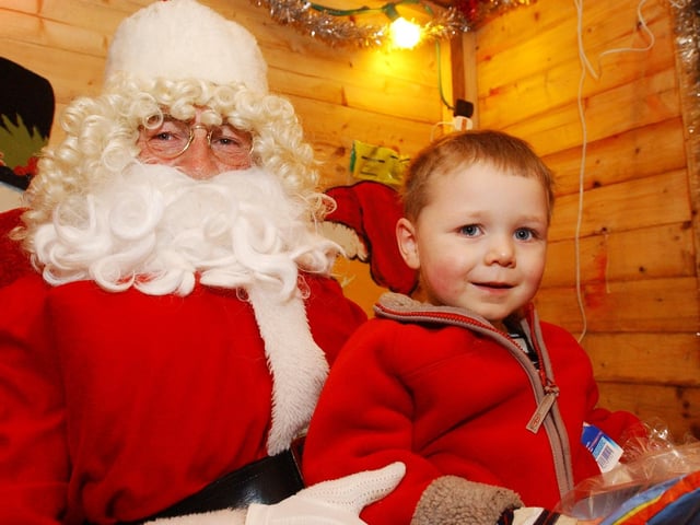 Conor Kelly White receives a present from Father Christmas. (0612PG62) : Christmas in Inishowen in 2005.