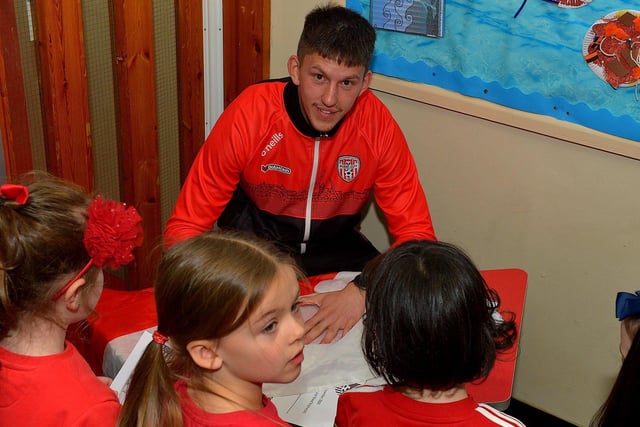 Derry City’s Jack Lemoignan signs autographs for pupils during a visit to Good Shepherd Primary School on Friday afternoon. Photo: George Sweeney. DER2247GS – 76