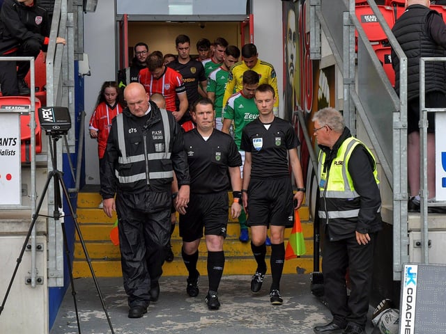 Match referee David Dunne leads the Derry City and Cork City teams onto the pitch at the Brandywell Stadium on Friday evening. Photograph: George Sweeney. DER2325GS – 93