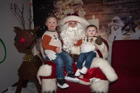 Brothers Tiernan and Aodhan telling Santa Claus that they have been good all year, during Monday's FDST Christmas Party.