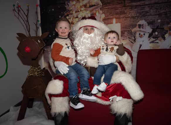 Brothers Tiernan and Aodhan telling Santa Claus that they have been good all year, during Monday's FDST Christmas Party.