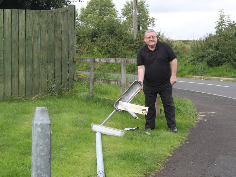 Sinn Fein Councillor Tony Hassan pictured with a broken lamp post in Ballyarnett.