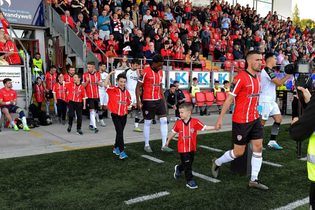 Sadou Diallo, pictured behind Michael Duffy as Derry City players and mascots walk out onto Brandywell, says the club are determined to finish season on a high.