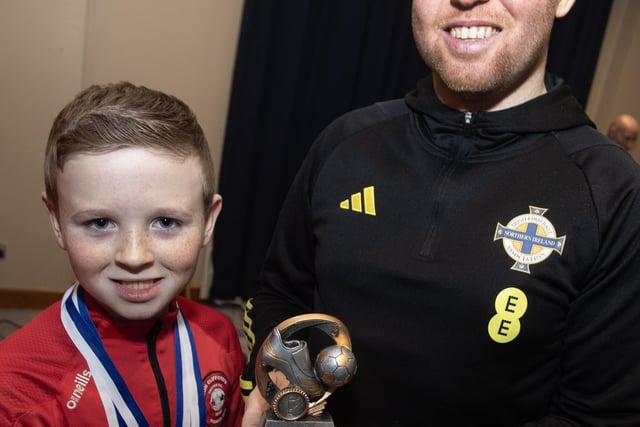 Young Aodhan McDevitt receiving the U9s Player of the Year award from Ronan O'Donnell.