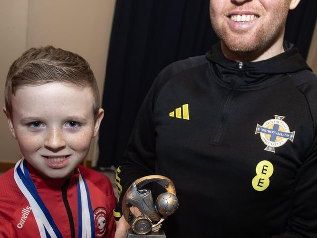 Young Aodhan McDevitt receiving the U9s Player of the Year award from Ronan O'Donnell.