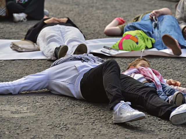 People taking part in a Freedom for Palestine march and rally “lay dead” on Shipquay Street, on Saturday afternoon, highlighting the number of Palestinians who have been killed by Israel. Photo: George Sweeney
