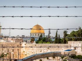 Jerusalem with the wall and the dome protected behind barbed wire at dusk