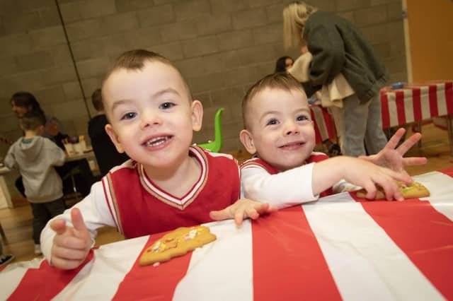 Three years-old Ollie and Kai McDonald enjoying some gingerbread men at Saturday's 'Christmas Get Together' at Long Tower Youth Club. : .