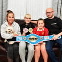 Seventeen-year-old Kickboxing World champion Aidan McCauley at home with his mum Emma holding Enzo the dog, his sister Daisy and dad Brian. Photo: George Sweeney