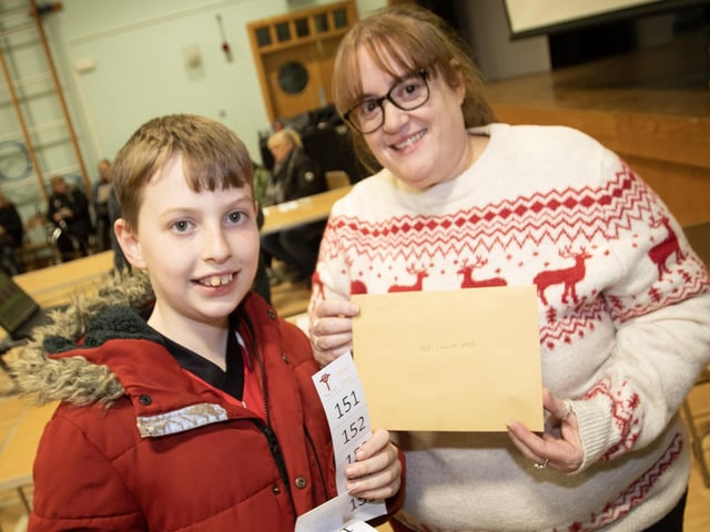 Peter Page picks up his prize from Lisa Grant at St. Joseph's Boys School Annual Christmas Rickety Wheel on Thursday night at the school.